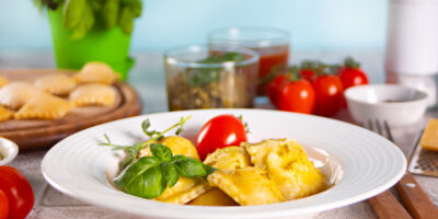 Homemade traditional italian ravioli pasta with basil tomato cherry vegetables table