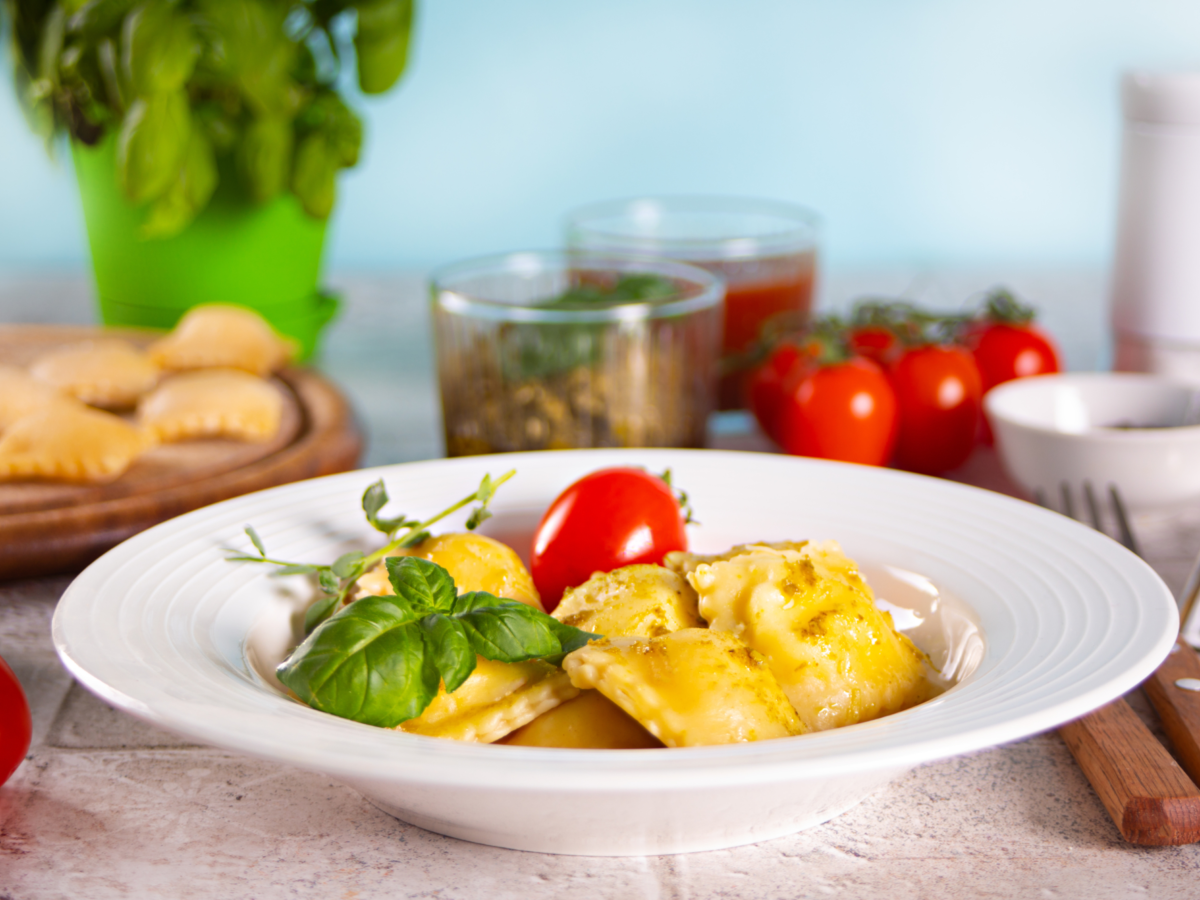 Homemade traditional italian ravioli pasta with basil tomato cherry vegetables table